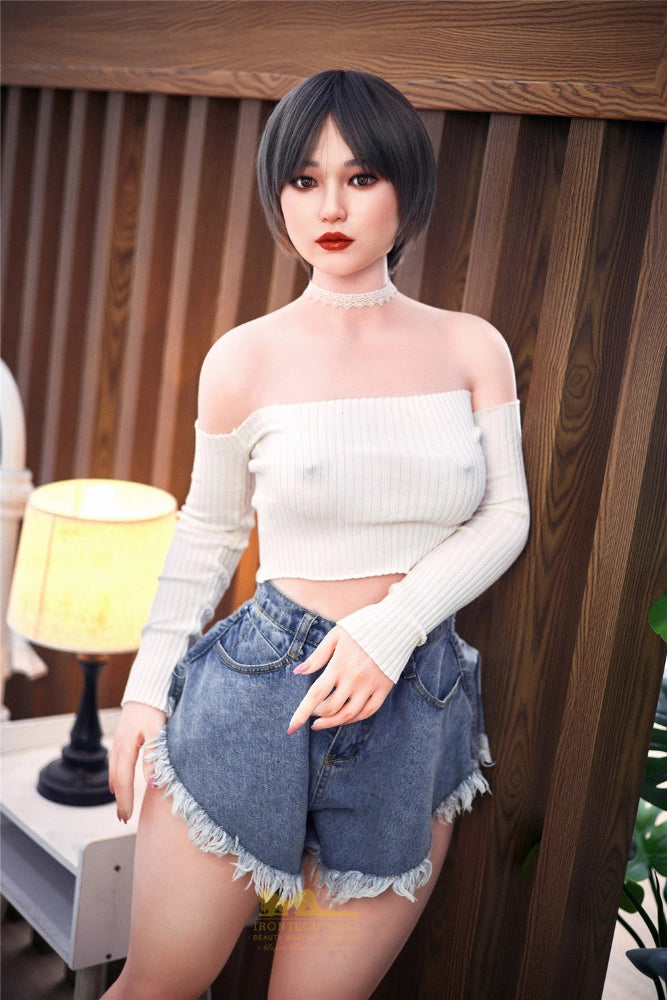 Asiatische Sexpuppe im Schlafzimmer stehend