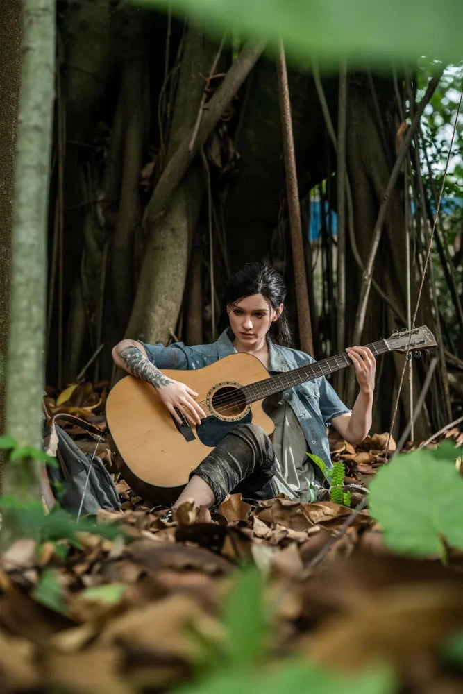 Person mit Gitarre im Wald