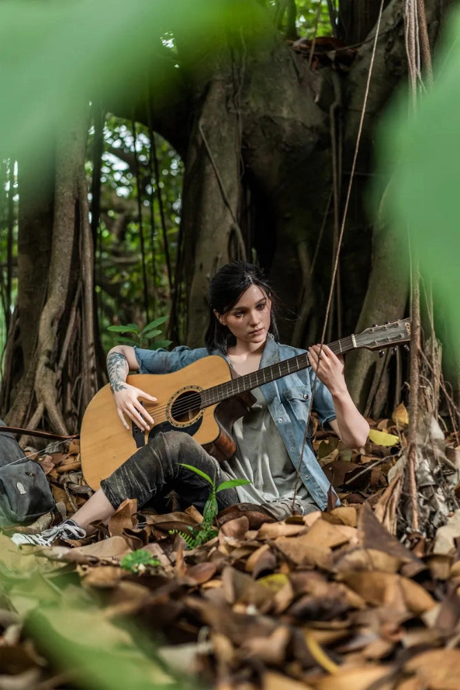 Person mit Gitarre im Wald