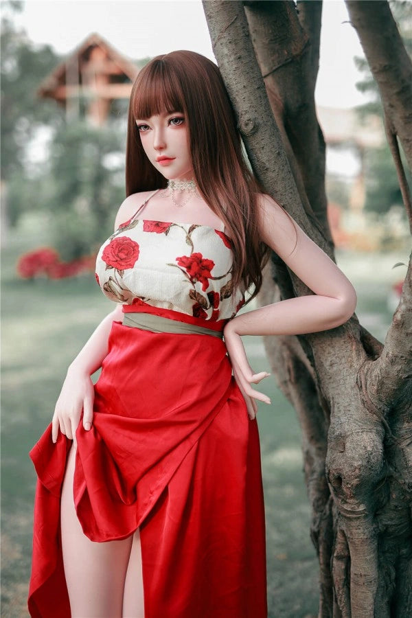Sexpuppe in rotem Kleid draußen