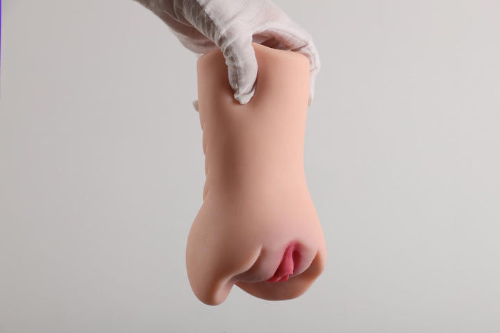 Sexpuppen-Torso in Hand gehalten