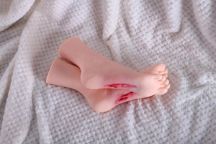 Sexpuppen-Füße auf weißem Stoff