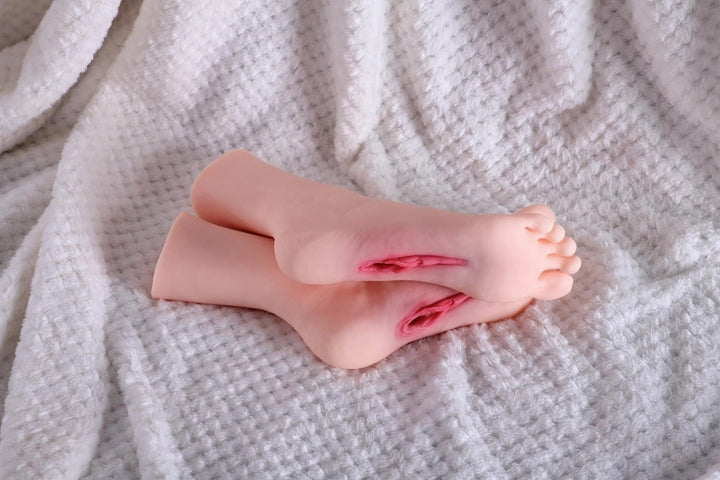 Sexpuppen-Füße auf weißem Stoff