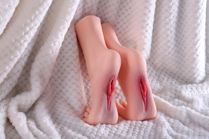 Sexpuppen-Füße auf weißem Stoff