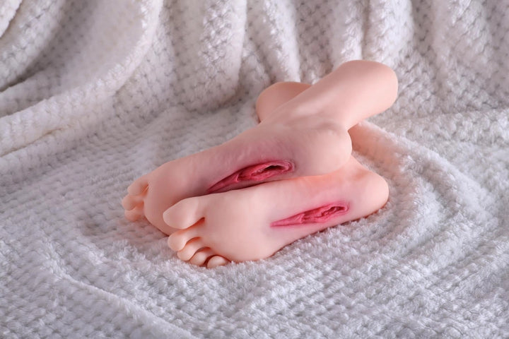 Sexpuppen-Füße auf weißem Stoff
