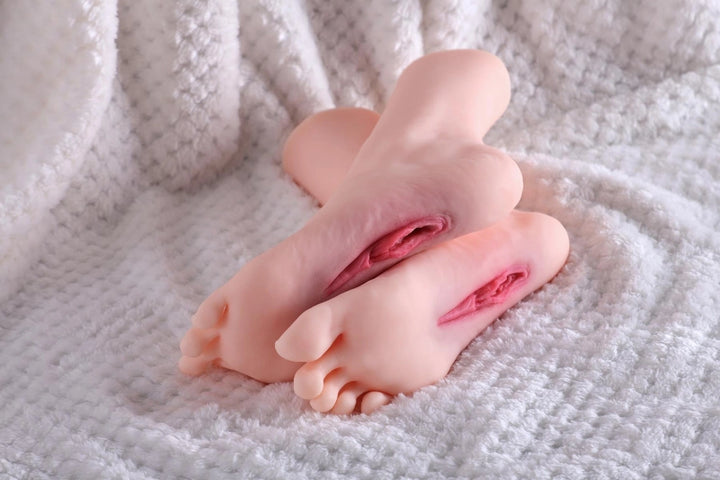 Sexpuppen-Füße auf weißem Stoff