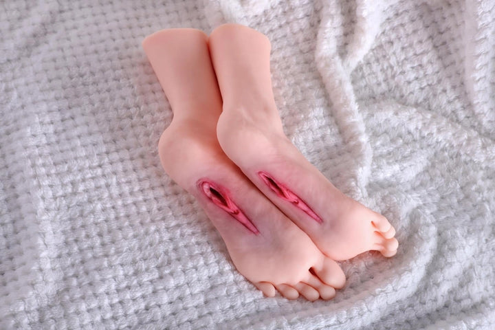 Sexpuppen-Füße auf weißem Hintergrund
