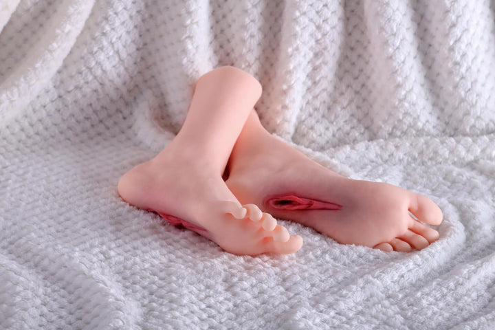 Sexpuppen-Füße auf weißem Stoff
