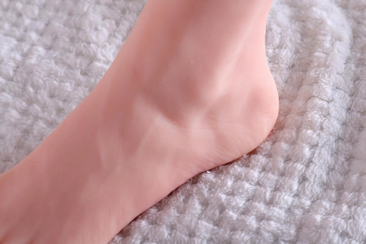 Sexpuppenfuß auf weicher Decke