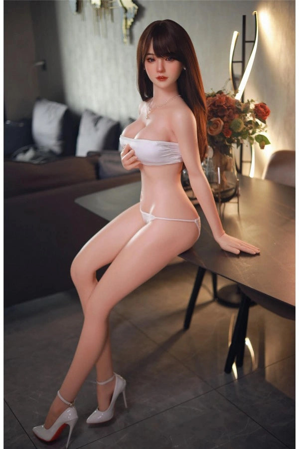 Realistische Sexpuppe auf Tisch sitzend