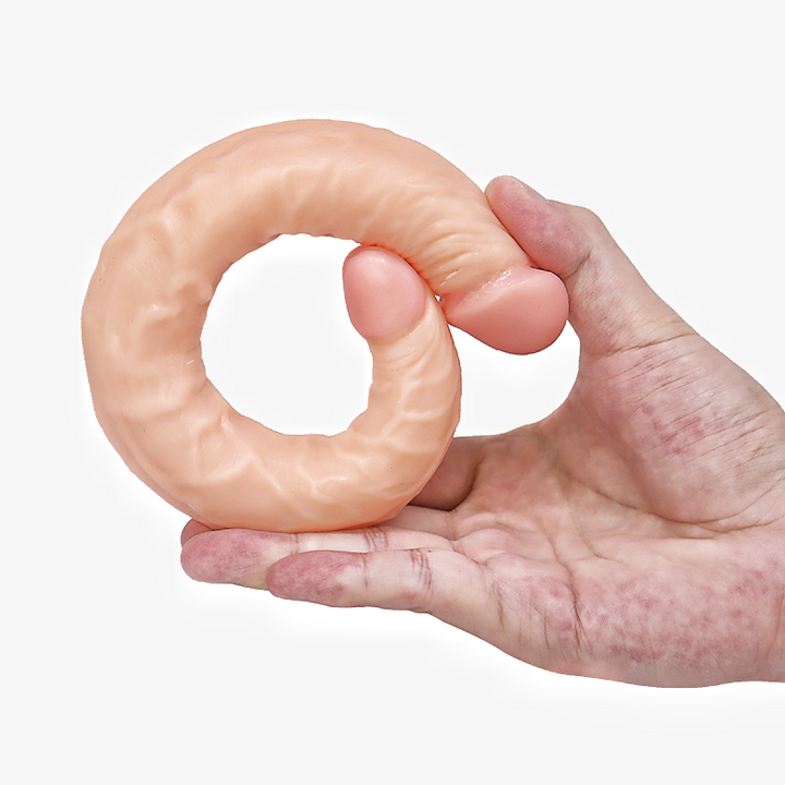 Hand hält gebogene Silikon-Sexpuppe