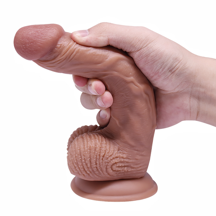 Hand hält realistischen Dildo fest